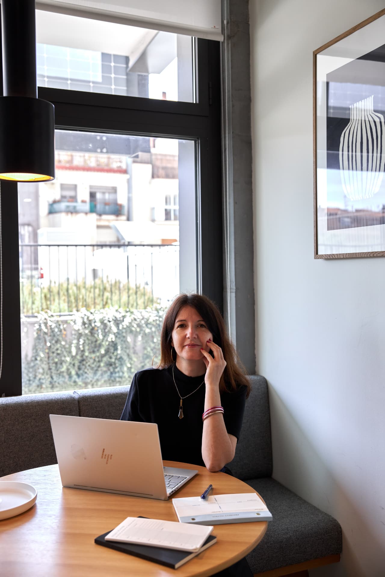 Zazie, founder of Zazie's Creative Tank, working at her laptop by the window